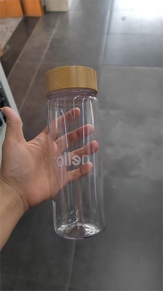 Clear bottle with bamboo lid and white logo